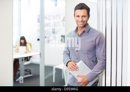 Portrait of businessman smiling in office Stock Photo
