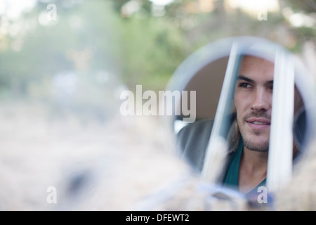 Reflection of man's face in side view mirror Stock Photo