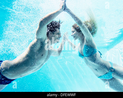 Couple touching hands underwater Stock Photo