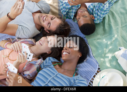 Friends playing cards on blankets outdoors Stock Photo