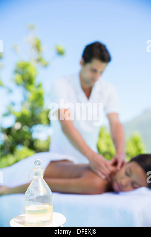 Woman receiving massage on spa patio