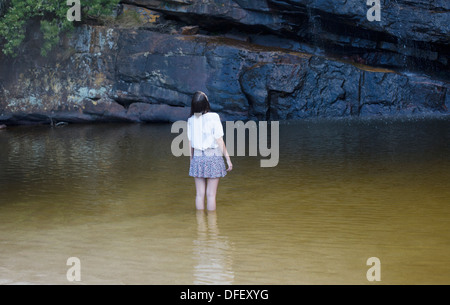 Woman wading and looking up in pool Stock Photo