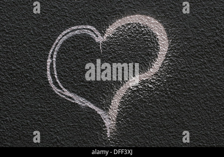 hand painted heart shape on black textured wall Stock Photo