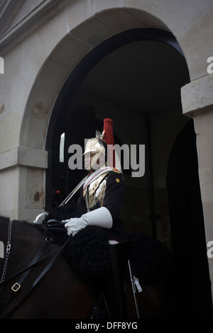 A black mounted lifeguard trooper parades at Horseguards in Whitehall, Westminster, Central London. This regiment is classed as a corps in its own right, and consists of two regiments: Life Guards (British Army) and the Blues and Royals (Royal Horse Guards and 1st Dragoons). They are the senior regular regiments in the British Army, with traditions dating from 1660. Stock Photo