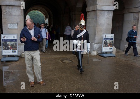 A black mounted lifeguard trooper parades at Horseguards in Whitehall, Westminster, Central London. This regiment is classed as a corps in its own right, and consists of two regiments: Life Guards (British Army) and the Blues and Royals (Royal Horse Guards and 1st Dragoons). They are the senior regular regiments in the British Army, with traditions dating from 1660. Stock Photo