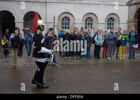 A black mounted lifeguard trooper parades at Horseguards in Whitehall, Westminster, Central London. This regiment is classed as a corps in its own right, and consists of two regiments: Life Guards (British Army) and the Blues and Royals (Royal Horse Guards and 1st Dragoons). They are the senior regular regiments in the British Army, with traditions dating from 1660. Stock Photo