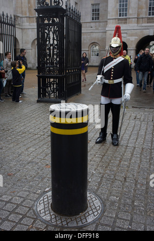 A black mounted lifeguard trooper parades at Horseguards in Whitehall, Westminster, Central London. This regiment is classed as a corps in its own right, and consists of two regiments: Life Guards (British Army) and the Blues and Royals (Royal Horse Guards and 1st Dragoons). They are the senior regular regiments in the British Army, with traditions dating from 1660. Stock Photo