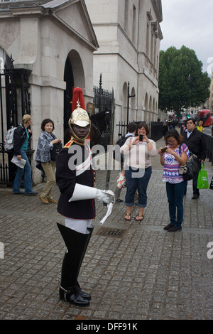 A black mounted lifeguard trooper parades at Horseguards in Whitehall, Westminster, Central London. This regiment is classed as a corps in its own right, and consists of two regiments: Life Guards (British Army) and the Blues and Royals (Royal Horse Guards and 1st Dragoons). They are the senior regular regiments in the British Army, with traditions dating from 1660. Stock Photo