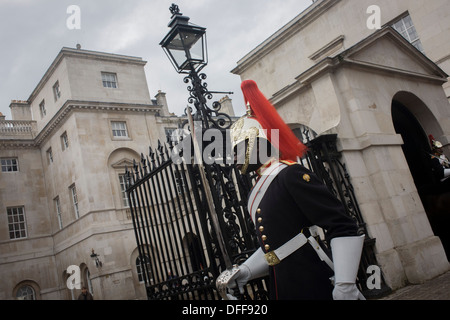 A black mounted lifeguard trooper parades at Horseguards in Whitehall, Westminster, Central London. This regiment is classed as a corps in its own right, and consists of two regiments: Life Guards (British Army) and the Blues and Royals (Royal Horse Guards and 1st Dragoons). They are the senior regular regiments in the British Army, with traditions dating from 1660. Stock Photo