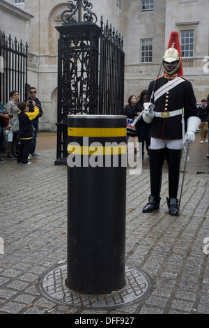 A black mounted lifeguard trooper parades at Horseguards in Whitehall, Westminster, Central London. This regiment is classed as a corps in its own right, and consists of two regiments: Life Guards (British Army) and the Blues and Royals (Royal Horse Guards and 1st Dragoons). They are the senior regular regiments in the British Army, with traditions dating from 1660. Stock Photo