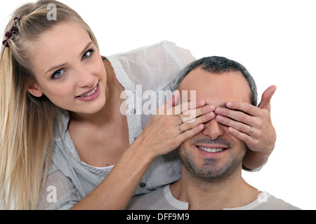 Woman covering a man's eyes Stock Photo