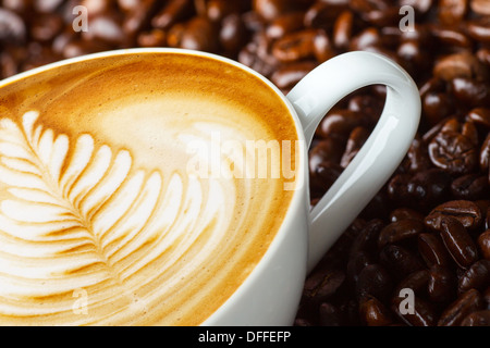 Latte art, coffee in coffee beans background Stock Photo