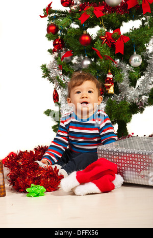Cheerful baby boy near Christmas tree with gifts Stock Photo