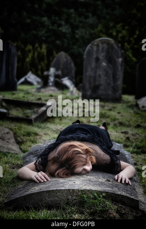 a woman is lying on a tomb Stock Photo
