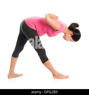 Prenatal yoga class. Full length healthy Asian pregnant woman doing yoga exercise stretching, full body isolated on white background. Yoga positions standing forward bend. Stock Photo