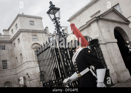 A black mounted lifeguard trooper parades at Horseguards in Whitehall, Westminster, Central London. This regiment is classed as a corps in its own right, and consists of two regiments: Life Guards (British Army) and the Blues and Royals (Royal Horse Guards and 1st Dragoons). They are the senior regular regiments in the British Army, with traditions dating from 1660. (Desaturated version). Stock Photo