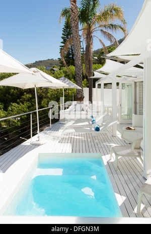 Swimming pool and lounge chairs on patio Stock Photo