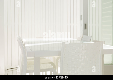 Table and chairs in white dining room Stock Photo