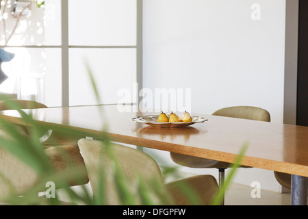 Pears in dish on dining room table Stock Photo