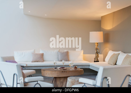 Fruit, cheese and wine on coffee table in modern living room Stock Photo