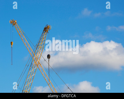 two yellow cranes crossed with blue sky and cloud Stock Photo