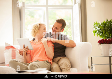 Couple using digital tablet on sofa Stock Photo