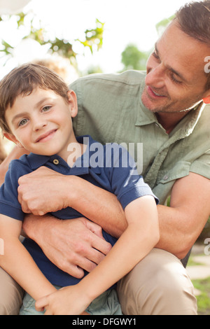 Father and son hugging outdoors Stock Photo