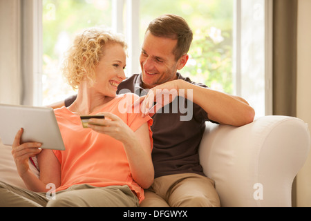 Couple shopping online on sofa Stock Photo