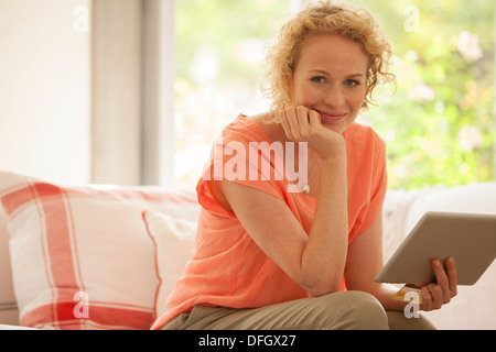 Portrait of woman using digital tablet on sofa Stock Photo