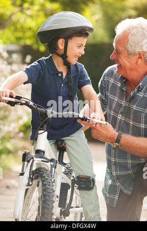 Grandfather teaching grandson to ride bicycle Stock Photo