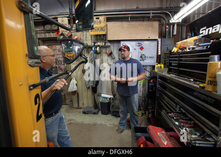 School Bus Mechanic Talks with His Union Representative Stock Photo
