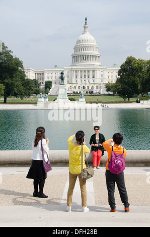 Asian tourists pose for pictures in front of the U.S. Congress during the budget shutdown of October 2013. Stock Photo