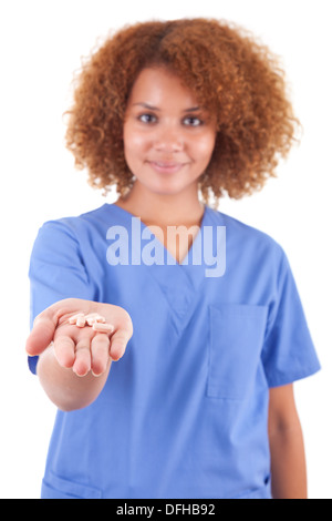 Young hispanic woman holding pills pointing thumb up to the side ...