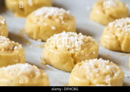 Raw sweet buns or bread rolls on a baking sheet with parchment ready for the oven Stock Photo