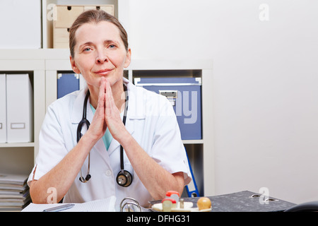 Attentive senior doctor listenint to patient in her office Stock Photo