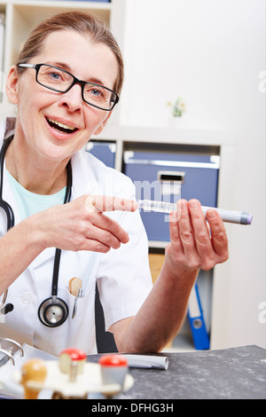 Senior doctor explaining syringe for insulin injection in her office Stock Photo