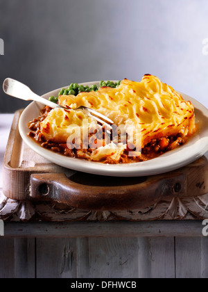 Traditional British minced beef cottage pie meal served on a plate in a table setting, ready to eat Stock Photo