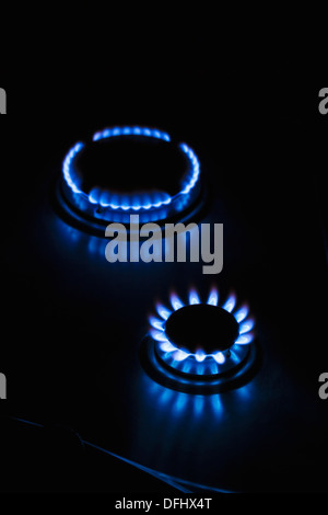 Gas hob cooker flames glowing ablaze in the dark Stock Photo