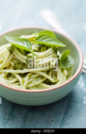 Pasta spaghetti with pesto sauce and fresh basil leaves in black stone ...
