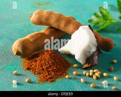 Whole tamarind pods, coconut, ground chilli powder & coriander seeds. Indain spices Stock Photo