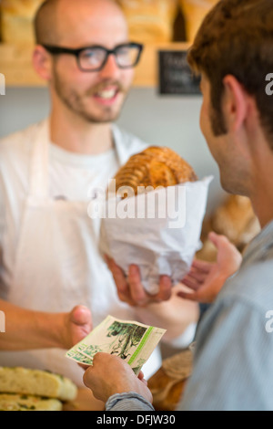 An artisan bakery in Bristol using the UK's first city wide local currency the Bristol Pound - a customer paying with local note Stock Photo