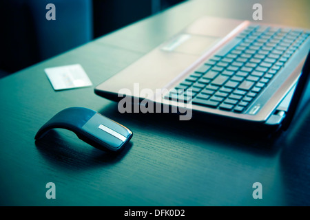 Human hand on computer mouse. Laptop on desk. Stock Photo