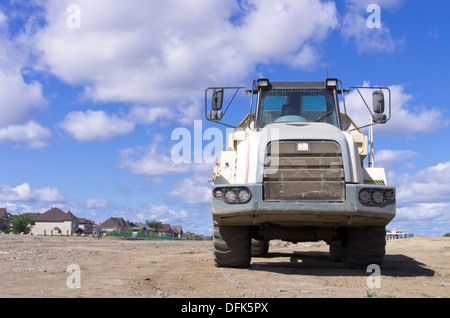 Dump truck on a residential development site against blue sky Stock Photo