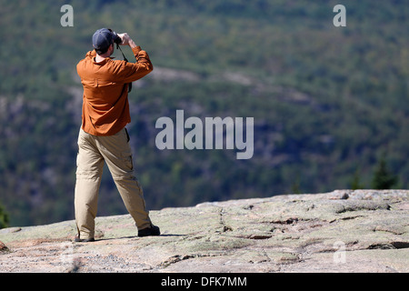 A man takes in the view from the summit of Cadillac Mountain, Acadia National Park, Maine, USA Stock Photo