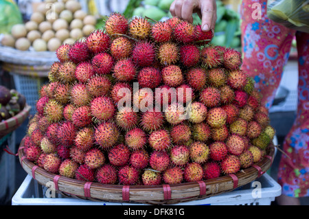 Basket of rambutan fruit for sale at market in Saigon, Vietnam. Stock Photo