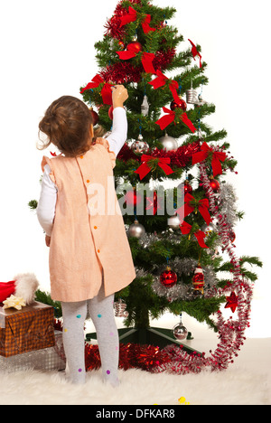 Back of little girl decorate Christmas tree Stock Photo