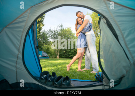 Portrait of a young couple hugging in front of a tent Stock Photo