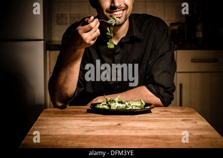 Happy young man having dinner at home Stock Photo