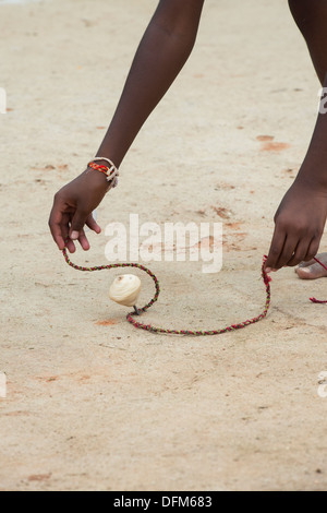 Rural Indian village boy playing with wooden spinning top toy. Andhra Pradesh, India Stock Photo