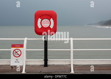 A lifebouy on Cromer Pier Norfolk UK in overcast light with strong saturated red colours Stock Photo